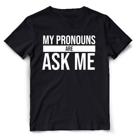 This black t-shirt is a simple yet powerful expression of gender inclusivity. The front of the shirt features white typography that reads "My Pronouns Are" followed by the wearer stating Ask Me..